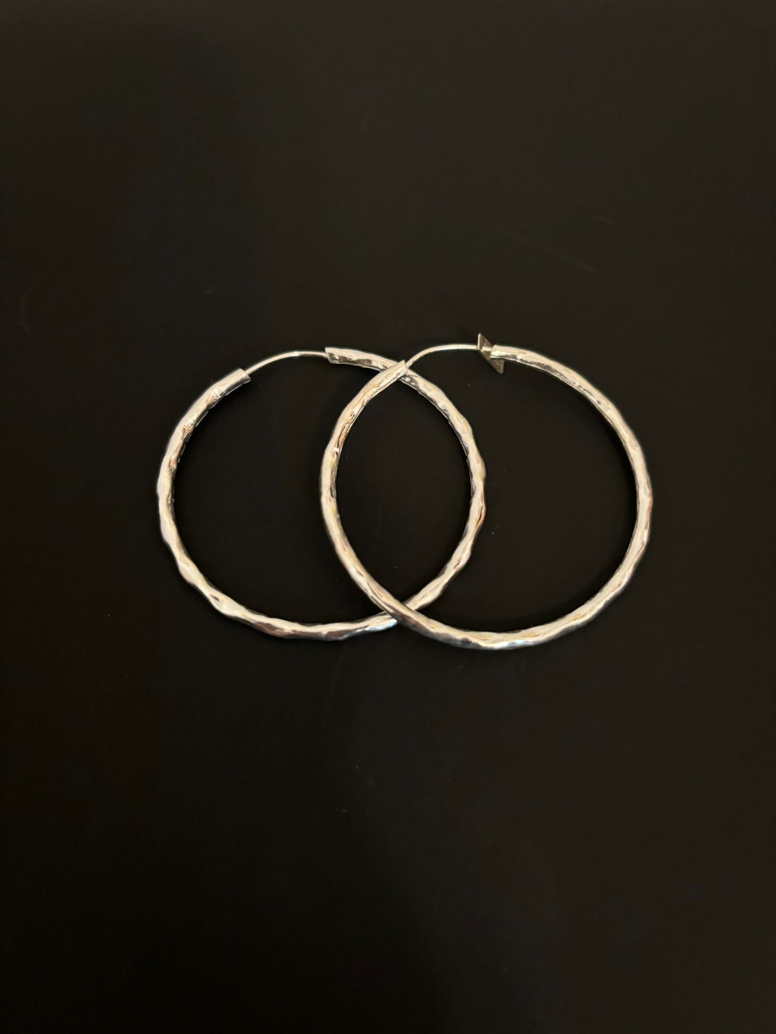 Silver hoop earrings with a diamond-cut design